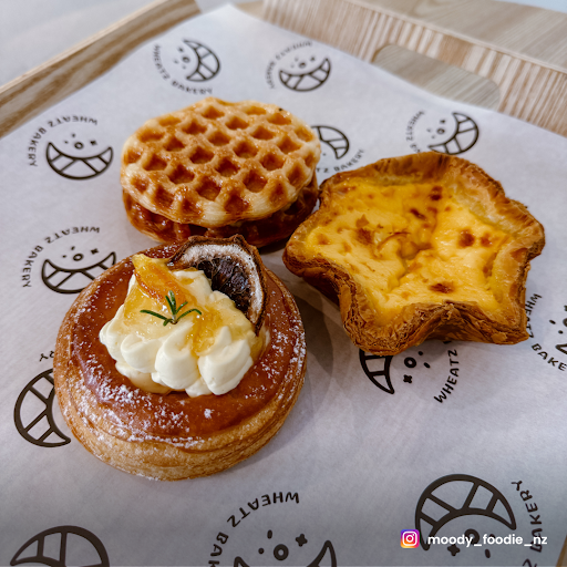 Pastries from Wheatz Bakery including an egg tart and decorated pastries.